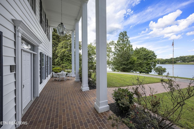 view of patio / terrace featuring a porch and a water view