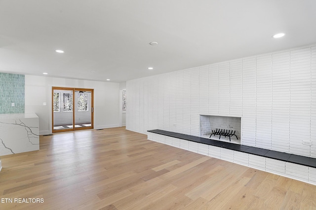 unfurnished living room featuring light wood-style floors, a fireplace, and recessed lighting