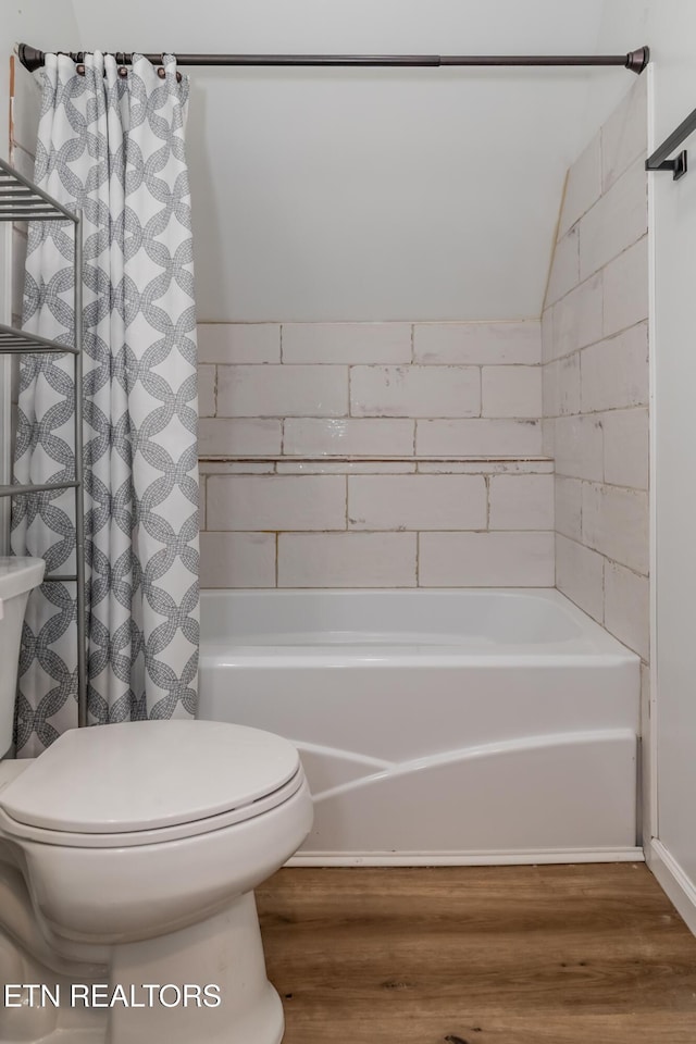 bathroom with shower / bathtub combination with curtain, toilet, and wood finished floors