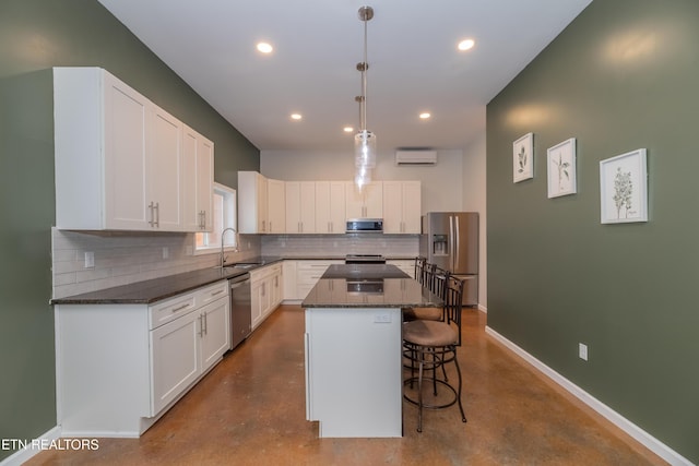 kitchen featuring a center island, finished concrete flooring, baseboards, stainless steel appliances, and a wall mounted AC