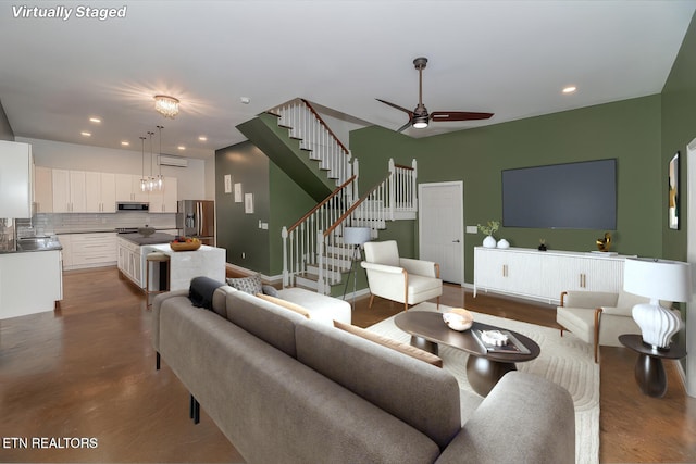 living area with recessed lighting, baseboards, a ceiling fan, and stairs