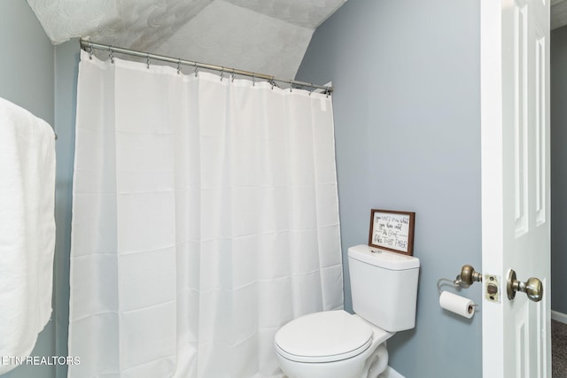 full bathroom with a shower with shower curtain and toilet