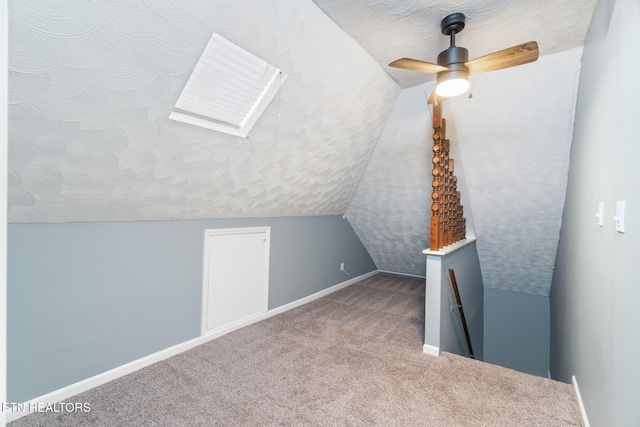 bonus room featuring carpet floors, baseboards, a textured ceiling, and lofted ceiling with skylight