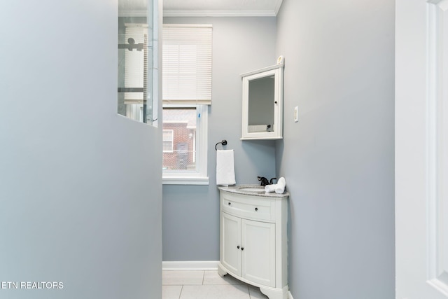 bathroom featuring tile patterned flooring, baseboards, ornamental molding, and vanity