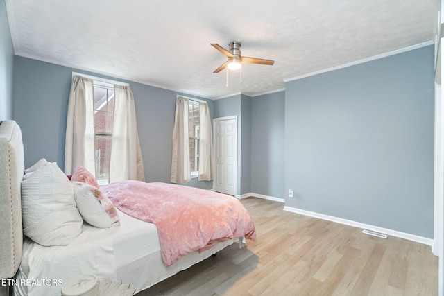 bedroom with ornamental molding, baseboards, ceiling fan, and light wood finished floors