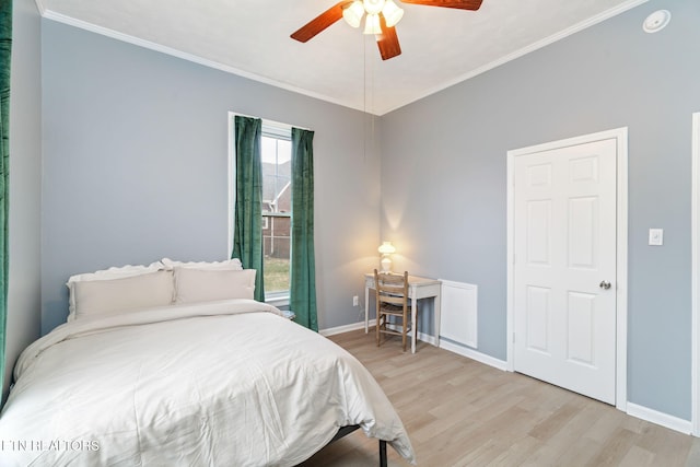 bedroom featuring ornamental molding, light wood-type flooring, ceiling fan, and baseboards