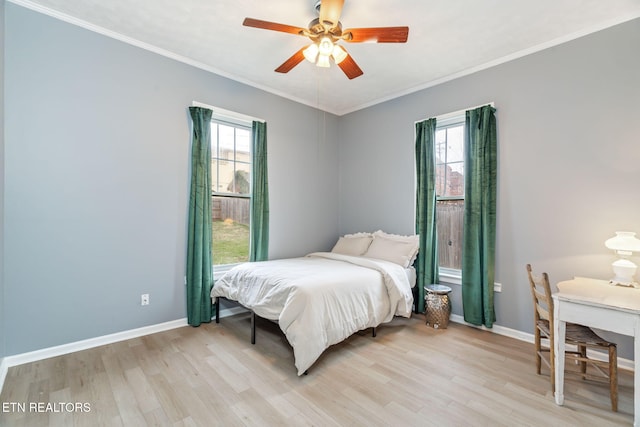 bedroom with multiple windows, light wood-style flooring, and baseboards