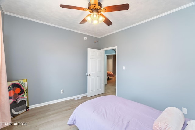 bedroom with crown molding, wood finished floors, a ceiling fan, and baseboards