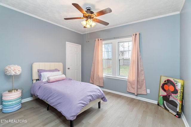 bedroom featuring ornamental molding, ceiling fan, baseboards, and wood finished floors