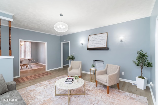 sitting room with crown molding and wood finished floors