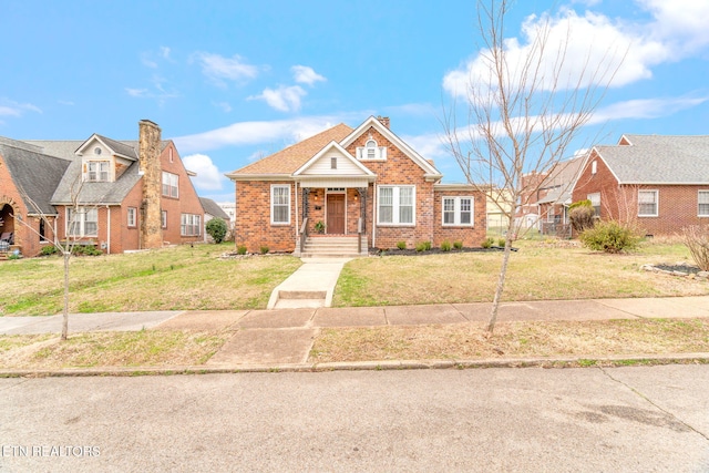 view of front facade featuring a front yard and brick siding