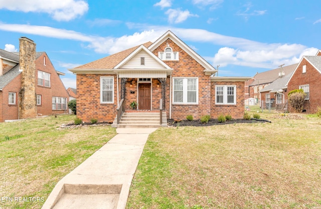 bungalow featuring brick siding, a front lawn, and a porch