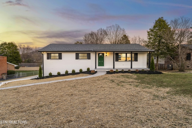 single story home featuring a yard, a porch, and fence