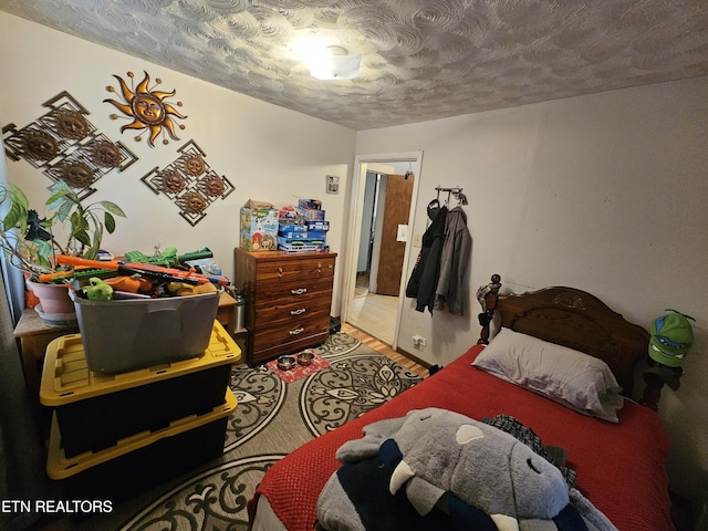 bedroom featuring light wood-style flooring and a textured ceiling