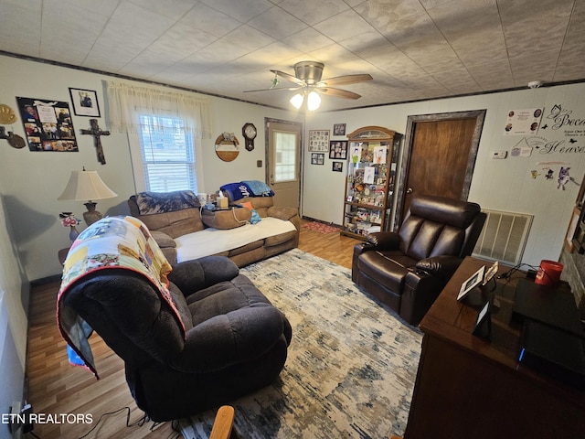 living room with ceiling fan, wood finished floors, and visible vents