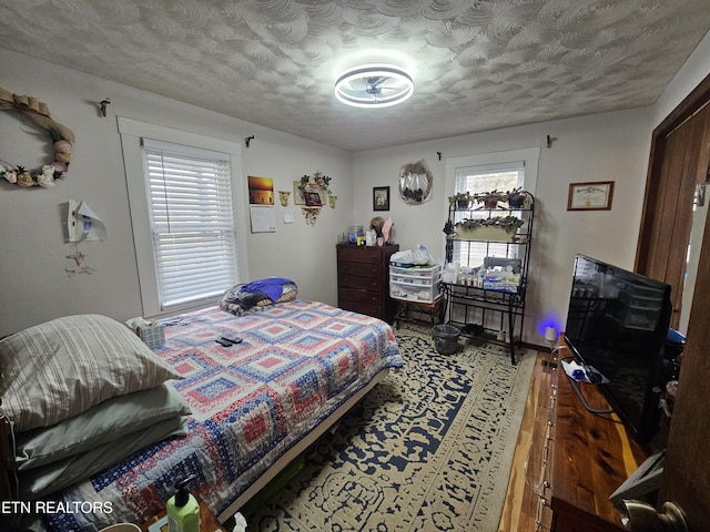 bedroom featuring a textured ceiling and wood finished floors