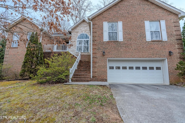 view of front of house featuring driveway, brick siding, stairway, and an attached garage