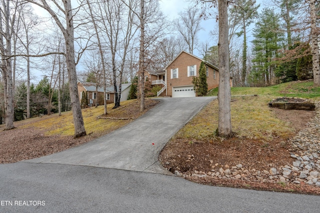 view of front of house with brick siding, an attached garage, and aphalt driveway