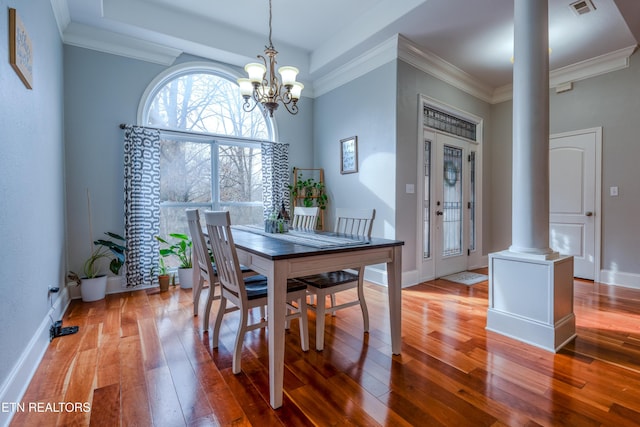 dining space featuring visible vents, light wood finished floors, decorative columns, and crown molding