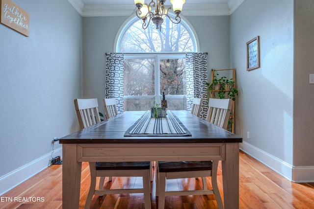 dining room with baseboards, a chandelier, wood finished floors, and ornamental molding