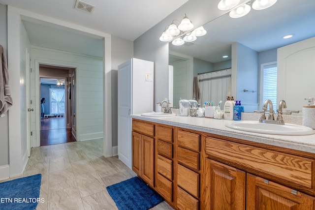 bathroom featuring visible vents, a sink, and double vanity