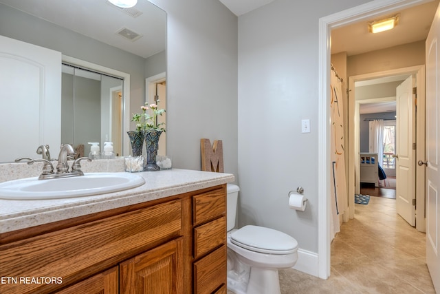 bathroom featuring visible vents, baseboards, toilet, tile patterned flooring, and vanity