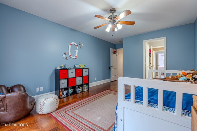 bedroom with ceiling fan, baseboards, and wood finished floors