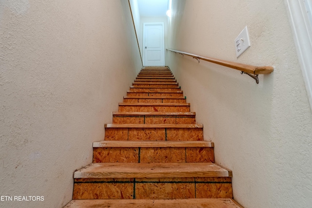 stairs featuring a textured wall