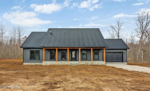 exterior space with a garage, metal roof, driveway, and board and batten siding