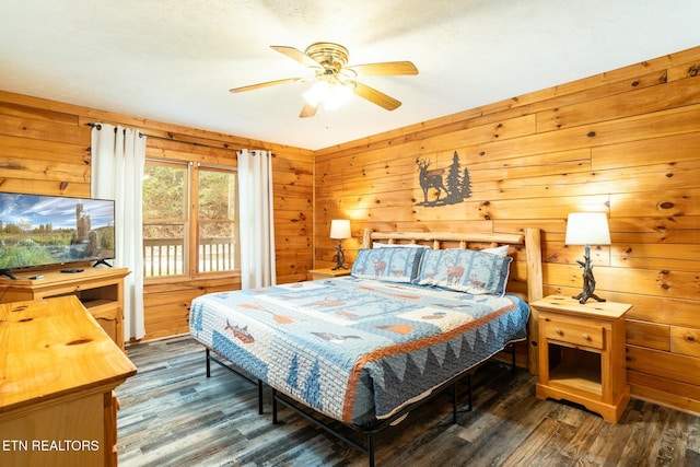 bedroom with a ceiling fan, wooden walls, and wood finished floors