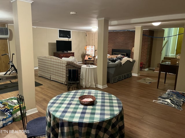 living room with a fireplace, baseboards, wood finished floors, and an AC wall unit