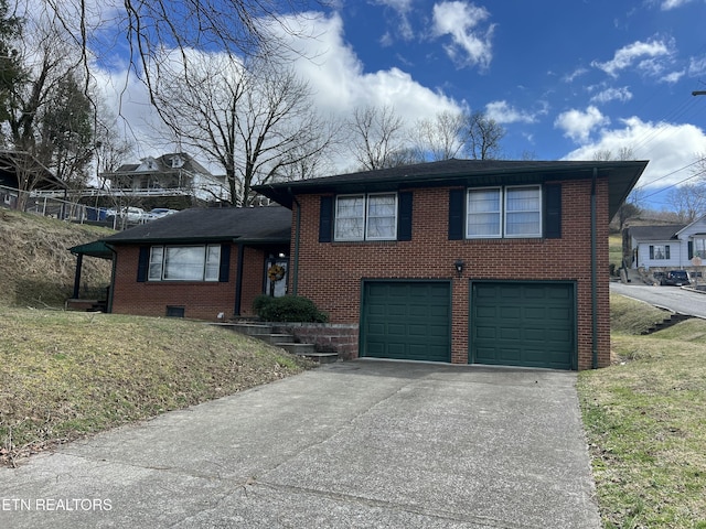 split level home featuring driveway, a garage, and brick siding