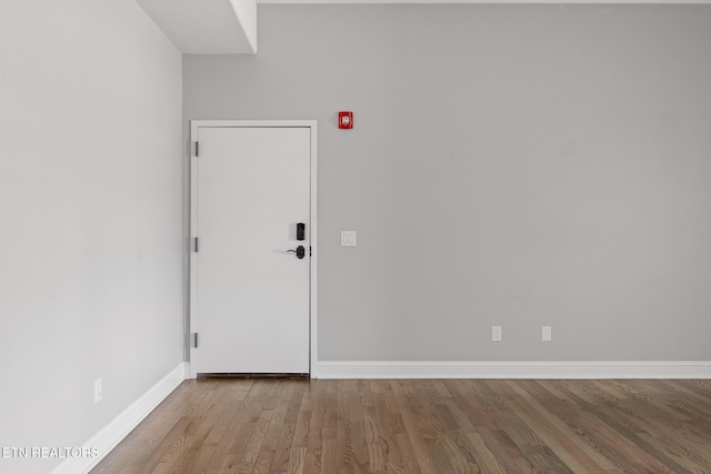 unfurnished room featuring baseboards and wood finished floors