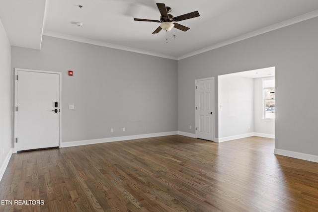 spare room with ornamental molding, baseboards, a ceiling fan, and dark wood-style flooring