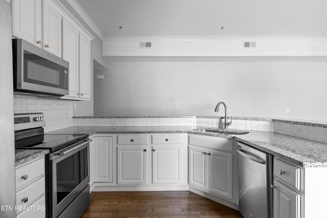 kitchen with visible vents, a sink, dark wood finished floors, appliances with stainless steel finishes, and crown molding