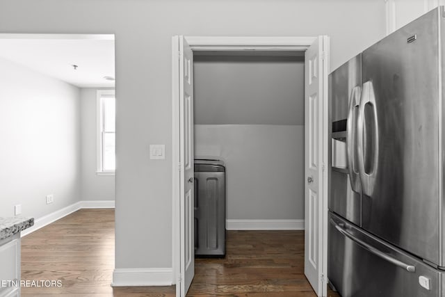 kitchen featuring wood finished floors, baseboards, washer / dryer, stainless steel fridge with ice dispenser, and light countertops