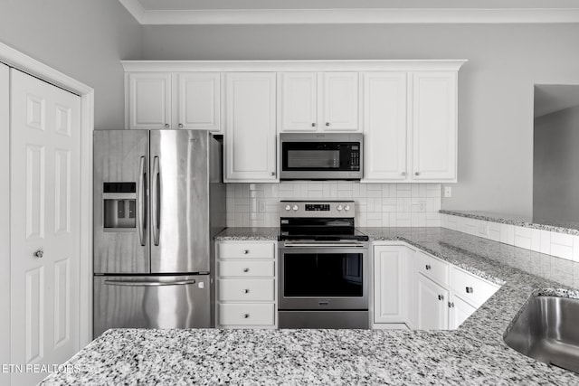 kitchen with white cabinetry, light stone counters, backsplash, and appliances with stainless steel finishes