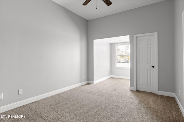 unfurnished room with baseboards, carpet, and a ceiling fan