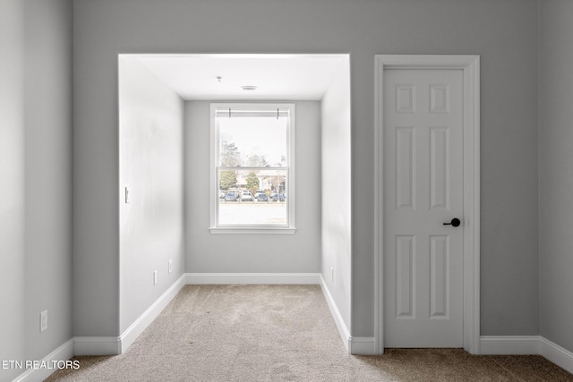 carpeted spare room featuring baseboards