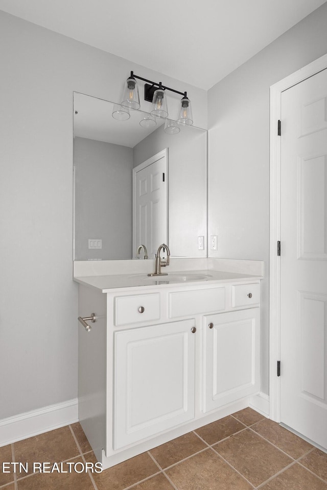 bathroom featuring vanity, baseboards, and tile patterned flooring