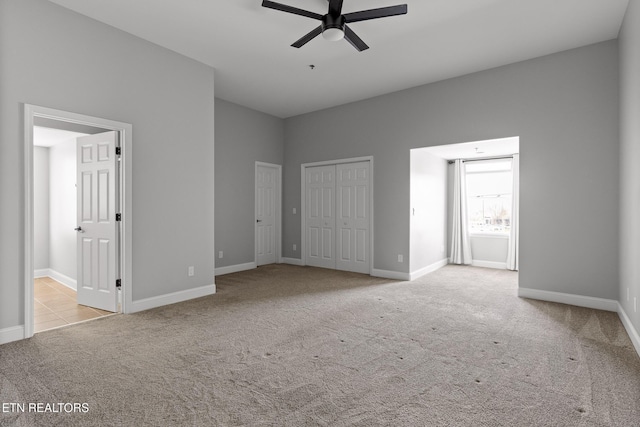 unfurnished bedroom featuring carpet flooring, a ceiling fan, and baseboards