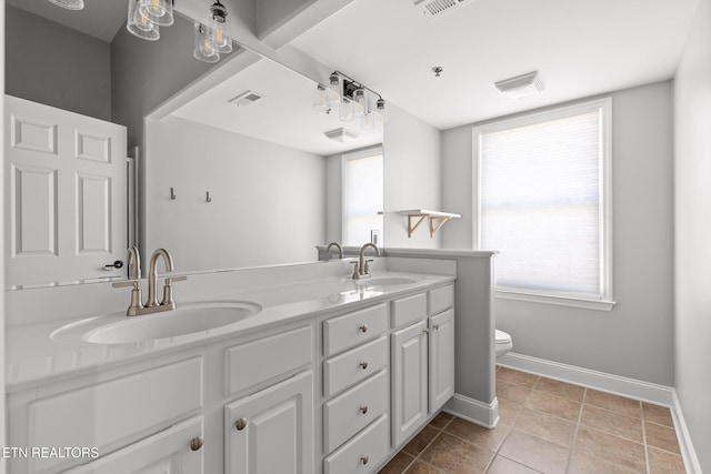 full bath with double vanity, toilet, baseboards, and a sink