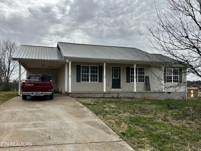 view of front of home featuring metal roof, covered porch, driveway, a carport, and a front lawn