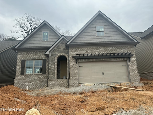 craftsman house with a garage and brick siding