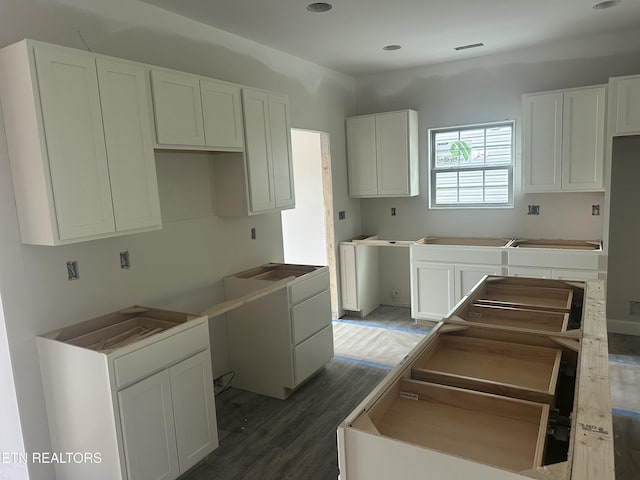 kitchen featuring white cabinetry, wood finished floors, and visible vents