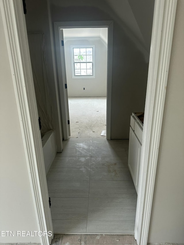 hall featuring vaulted ceiling