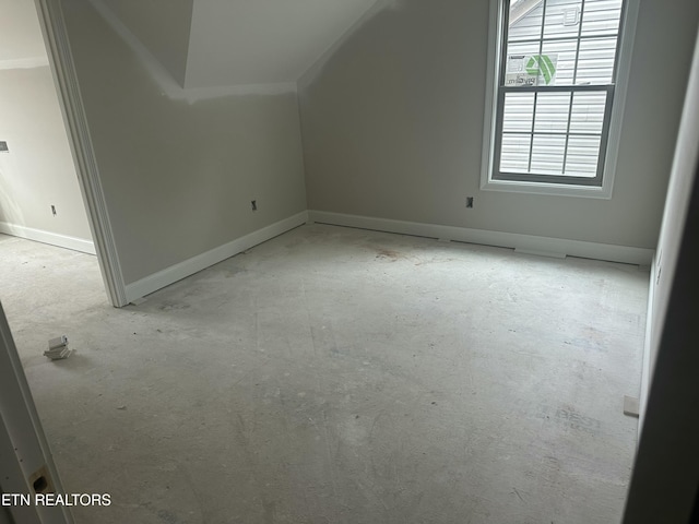 additional living space with lofted ceiling and baseboards