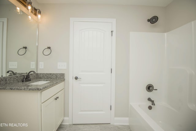 full bathroom with tub / shower combination, vanity, and baseboards