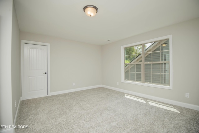 spare room with carpet and baseboards