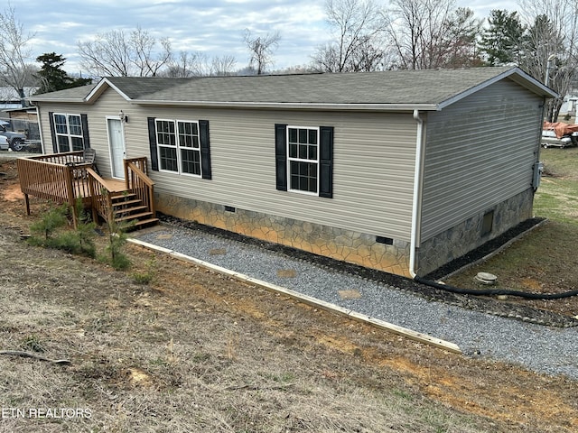 exterior space featuring crawl space, roof with shingles, and a wooden deck